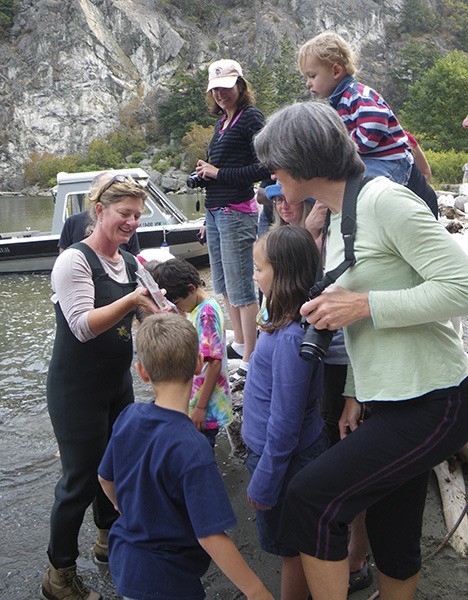 Lopez teacher and Kwiaht volunteer Lorri Swanson on the beach with visitors at Watmough Bight.