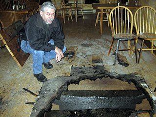 San Juan County Fire Marshal Robert Low surveys the fire damage at Chimayo restaurant