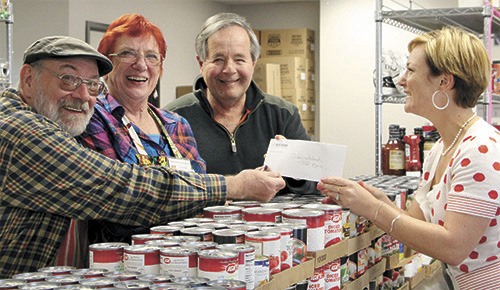 Islands’ Sounder publisher Colleen Smith Armstrong hands over a check for $270 to President of the Orcas Island Food Bank Tom Murdock (middle) and volunteers Maggie Kaplan and Ezekiel Barr.