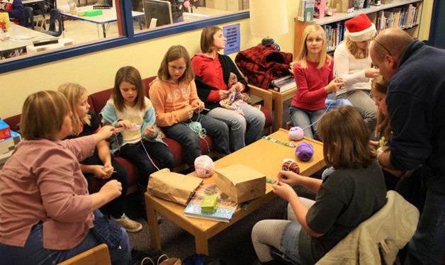 Greg White and Cheryl Jackson help 4th-6th graders learn to knit during lunchtime.