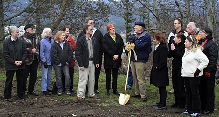 Food bank volunteers gather to break ground for the new building. Project manager George Post is pictured above with the golden shovel.