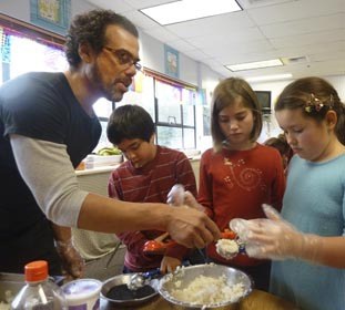 Charles helps Flora Lister and Zora Leck form a rice cake while Douglas Ha dips another in a pool of sesame seeds.