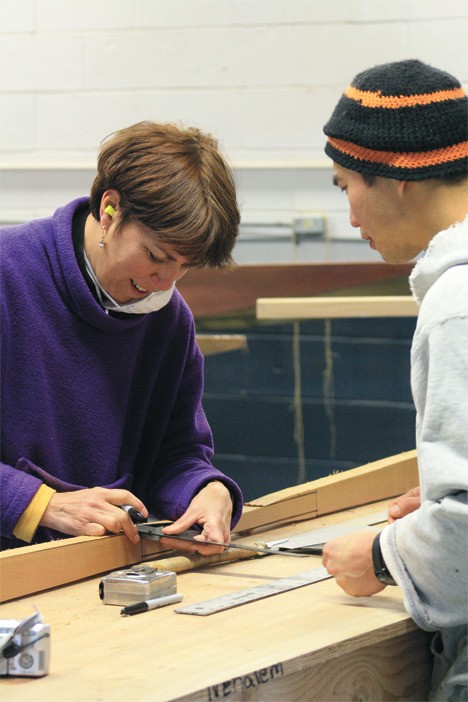 David Kau and Wendy Michnay make measurements for a wooden 'stick paddle.'