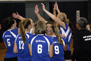 Lady Vikings gather round to high-five their victory against the Wolverines.