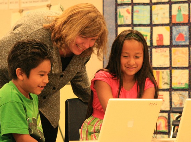 Catherine Laflin helps ELL students Soeth Quintero and Jaquelyn Figuero with their work.