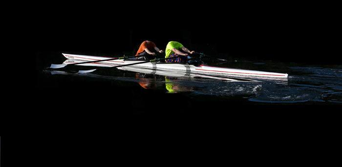 Headless rowers practice on the black waters of Cascade Lake