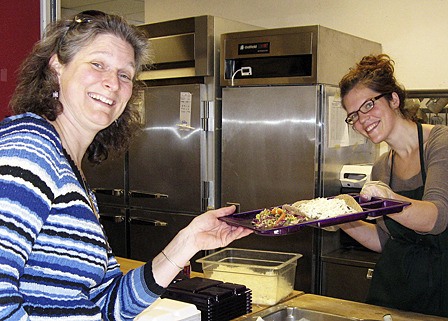 Abigael Birrell serving lunch to Jill Sherman.