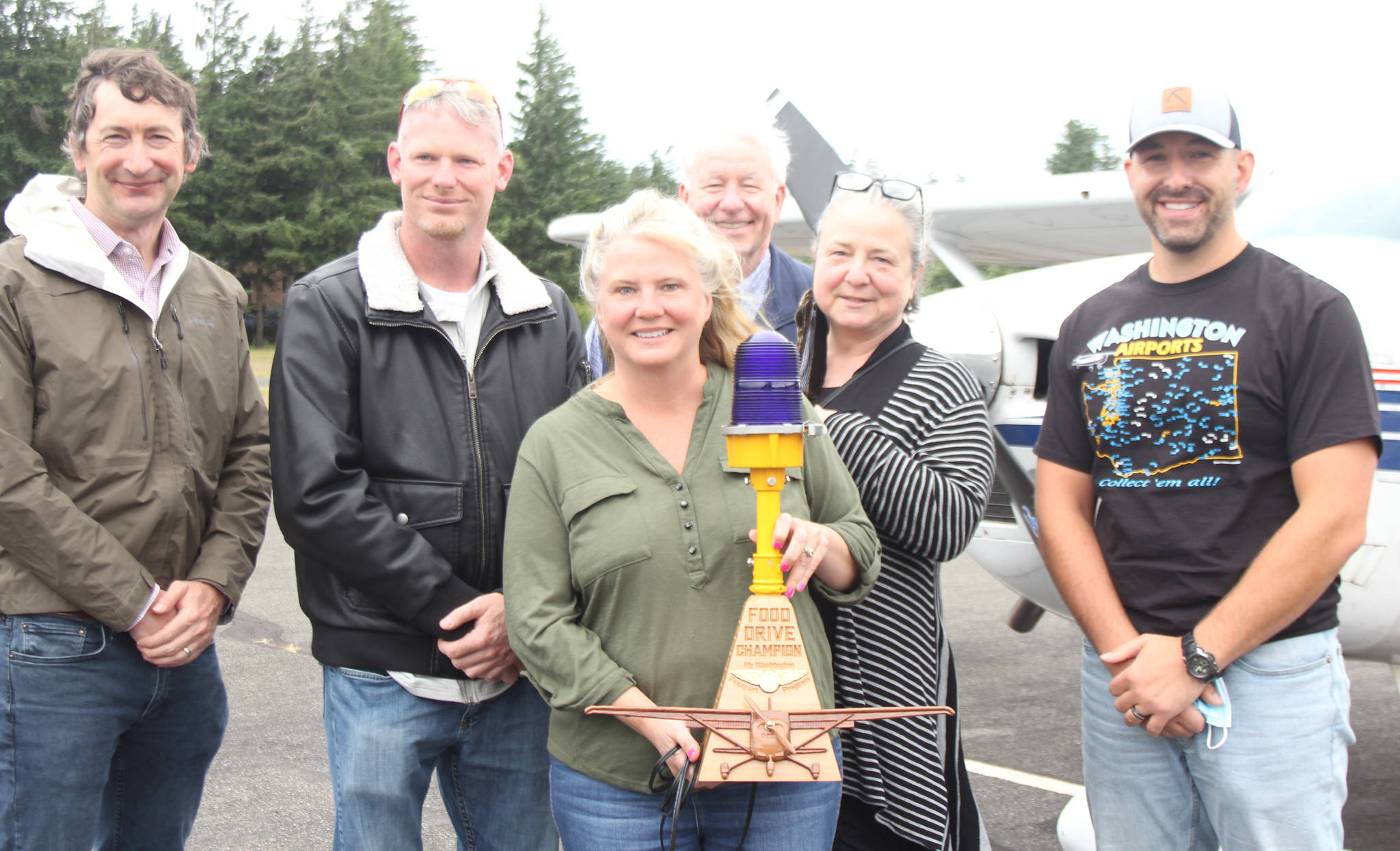 Diane Craig/staff photo
For the Port’s winning efforts, airport manager Jeannie Sharp (center) was presented with a wooden sculpture. To Sharp’s right is Port commissioner Jason Laursen and to her left is commissioner Mia Kartiganer. They are pictured with board members of the Passport program.