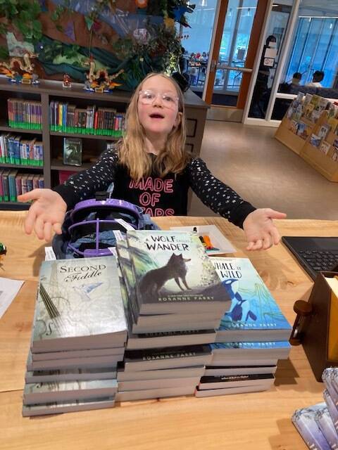 Larkin Remy with books to be given away to 3rd-grade students after the author signs copies.