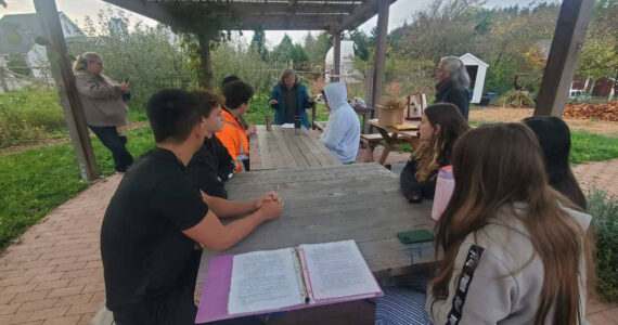 <em>Students and teacher Anna Vedder learn about composting and the impact it can have. </em>